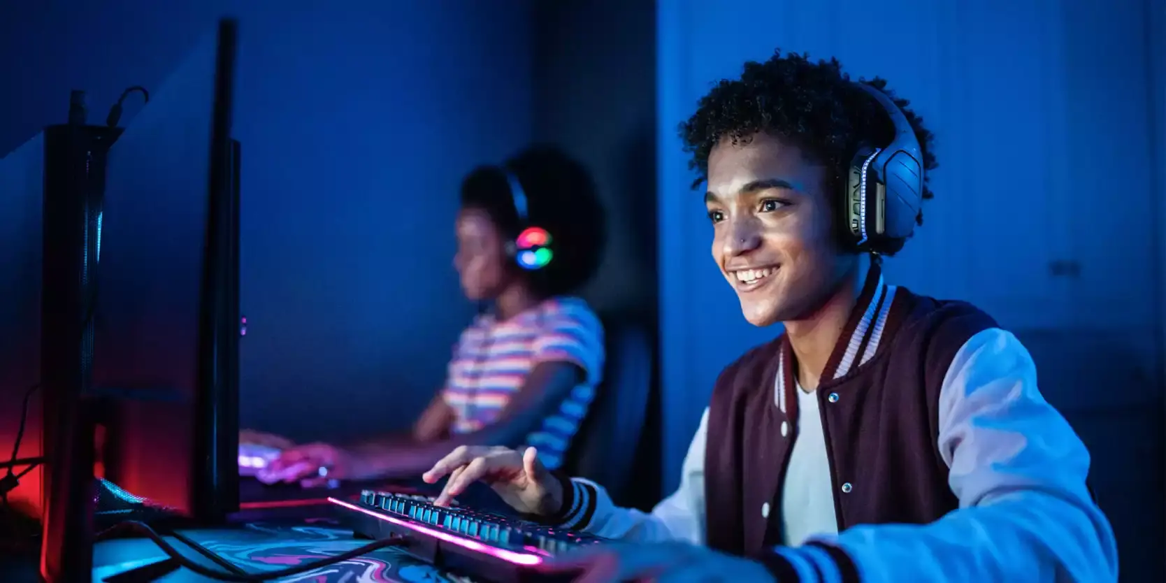 Two teens having fun on computers